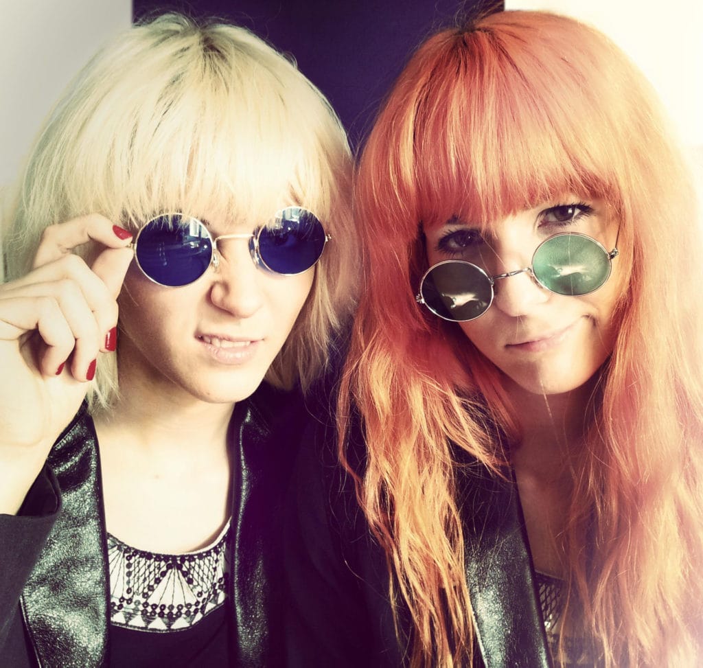 Portrait of MonaLisa Twins wearing blue and green 60's specs