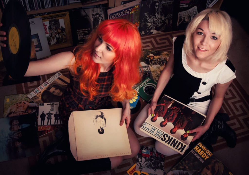 MonaLisa Twins sitting on the floor and sifting through an old 60's vinyl collection